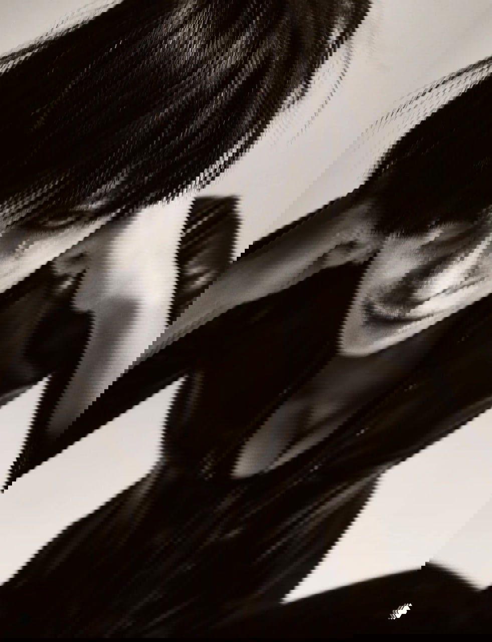 Крупный монохромный кадр: модель в кожаном образе с короткой стрижкой, интенсивный макияж и драматичная светотень в художественном ключе.