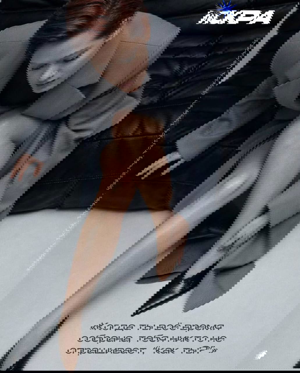 Глянцевая фотосессия: женщина в пальто поправляет туфлю, акцент на ногах и образе, кадр передаёт стилистику журнальной съёмки.