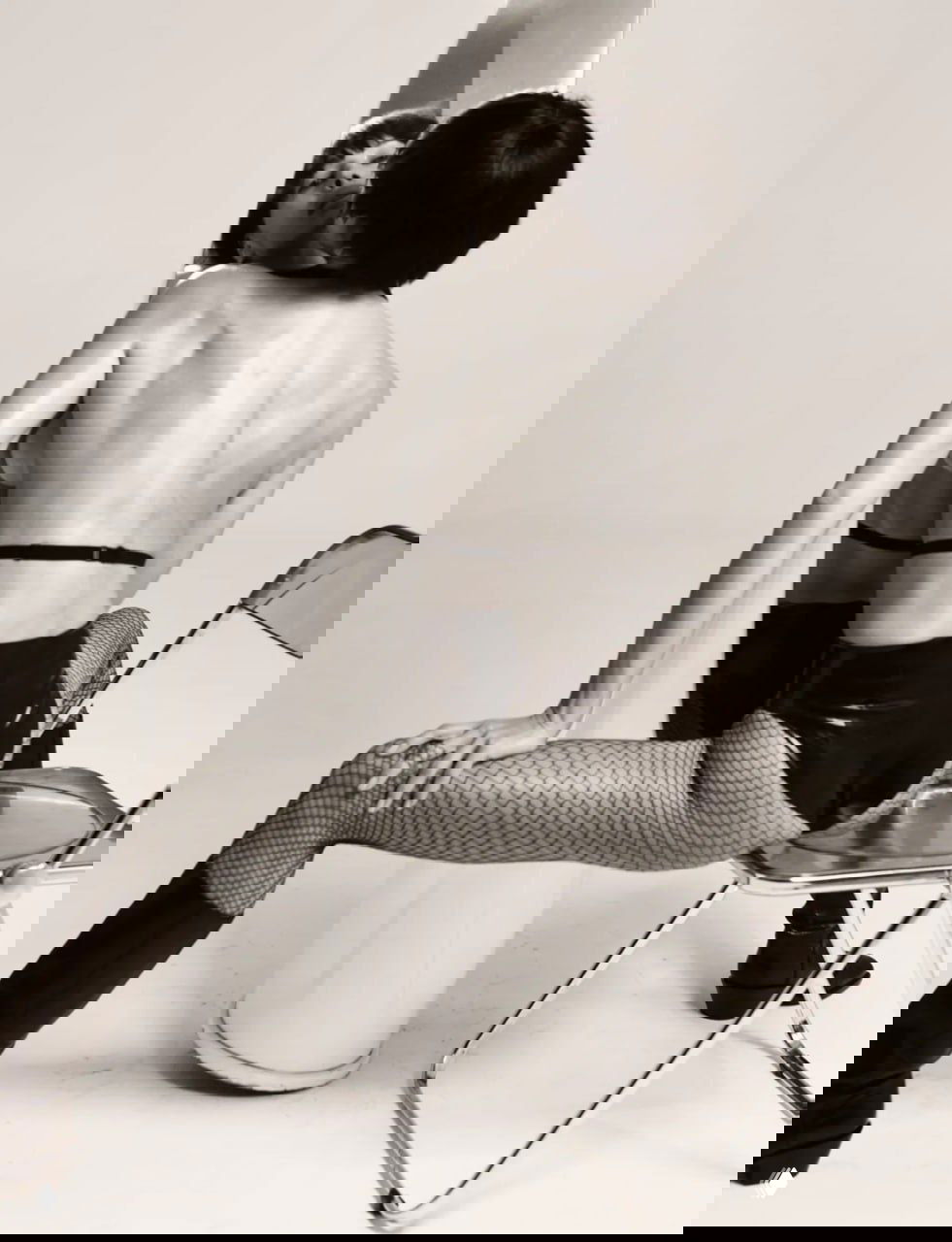 Динамичное цветное фото: Ирина Шейк в прозрачном топе в движении, подчеркнутый контраст кожи и студийного фона, эмоциональная пластика тела.