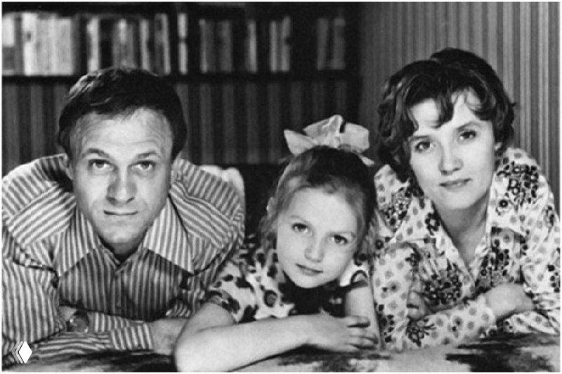 Архивное чёрно-белое семейное фото с цифровыми полосами и дисторсией: трое людей лежащих рядом, изображение частично искажено.