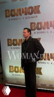 Даниил Воробьёв на красной дорожке светской премьеры фильма «Волчок», позирует на фоне баннера с названием фильма и логотипом.