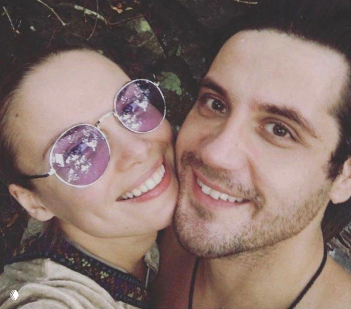 Улыбающиеся Марк Богатырев и Татьяна Арнтгольц на крупном плане: совместное селфи, отражение в очках, естественная сцена.