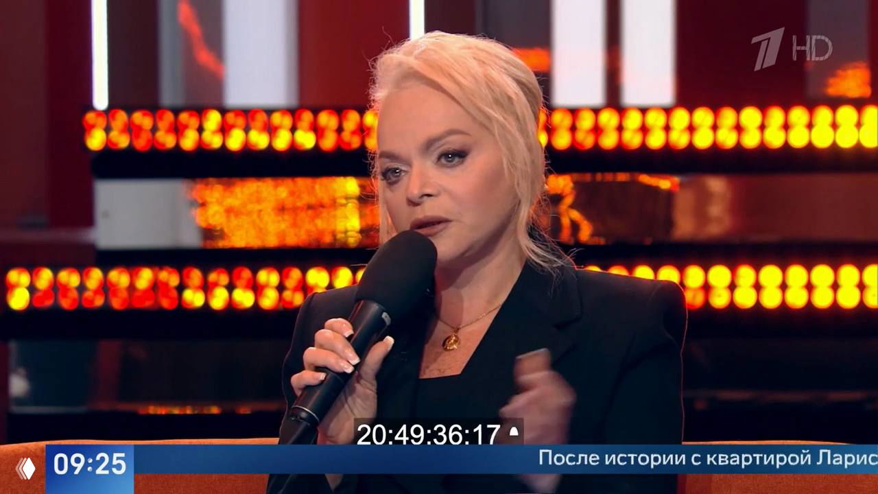 Кадр: Лариса Долина в студии телешоу «Пусть говорят», держит микрофон и рассказывает о слежке мошенников за её детьми
