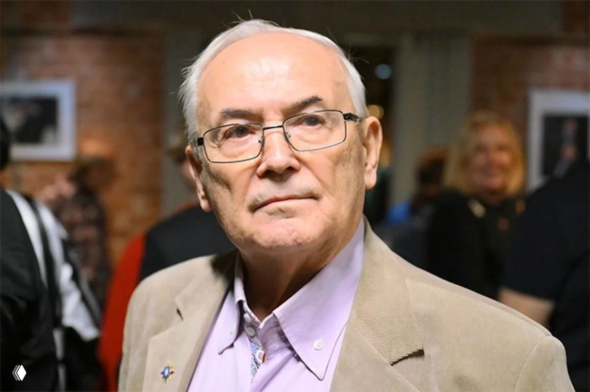 Фотография актёра и режиссёра Всеволода Шиловского в зале: крупный план лица в очках, пиджак, спокойное выражение.