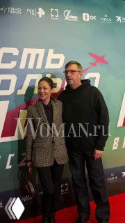 Владимир Вдовиченков и Елена Лядова на красной дорожке в «Октябре» на фоне постера фильма; виден водяной знак WOMAN.ru