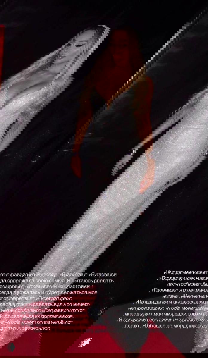 Анна Седокова в сверкающем вечернем платье в полный рост на тёмном фоне, поза и наряд подчёркивают образ звезды на мероприятии.