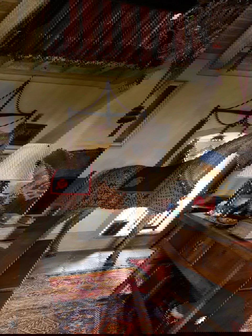 Большая комната замка Килко с деревянной скульптурой лошади, старинными коврами и мебелью в стиле антик, тёплый тон отделки и декора.