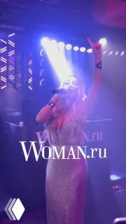 Анна Седокова поёт на сцене во время музыкального вечера; яркая подсветка, поднятая рука и эмоциональное исполнение хита