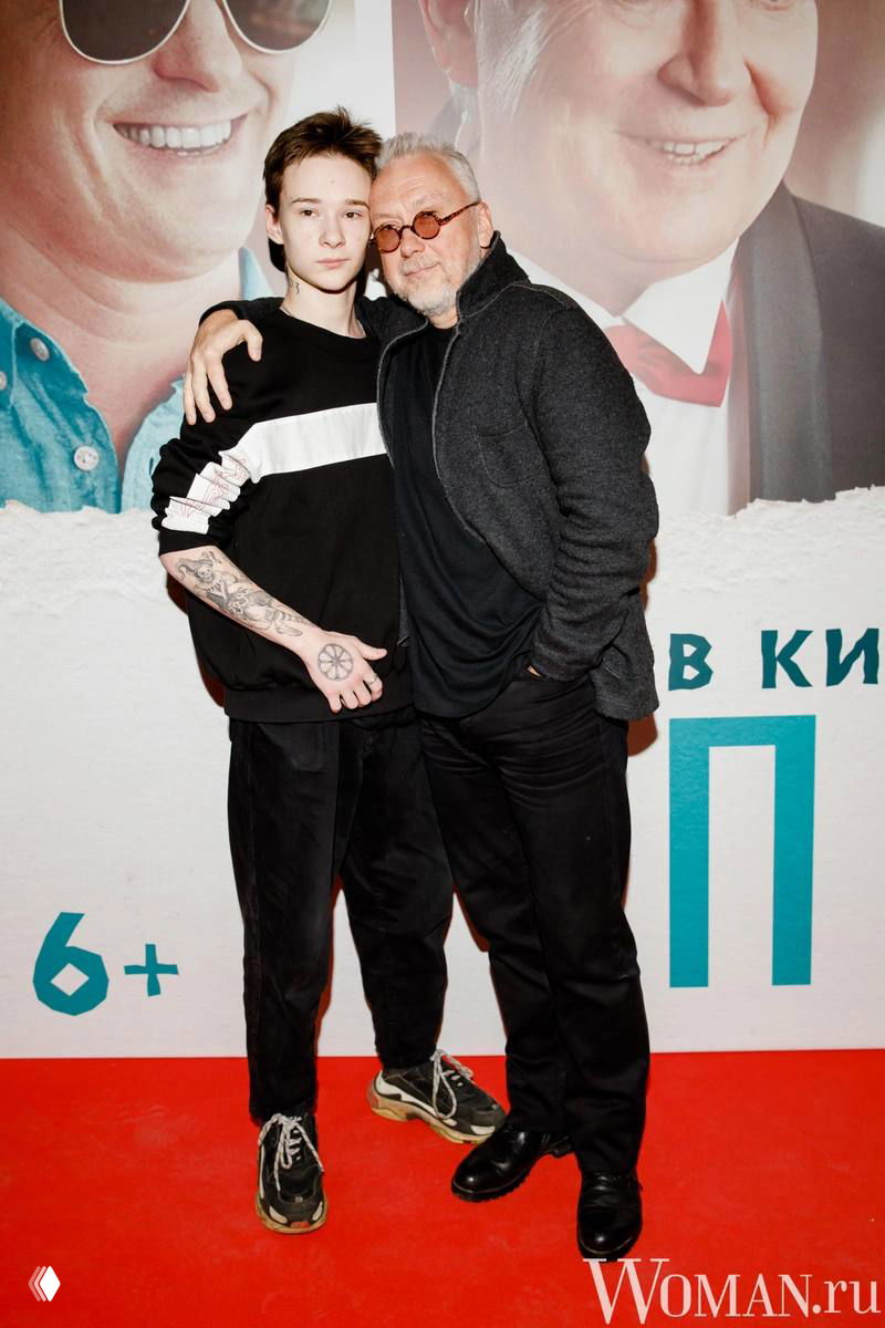 На фото молодой мужчина и взрослый мужчина на красной дорожке у постера фильма — отец и сын, иллюстрация к новости.