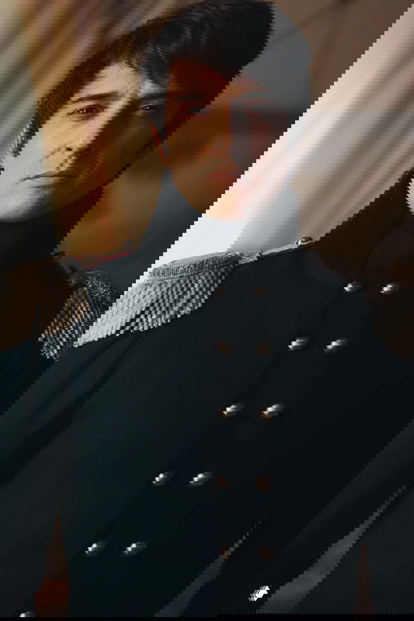 Крупный план Станислава Бондаренко в тёмной мундире с серебряными эполетами, драматичное освещение подчёркивает черты лица актёра.