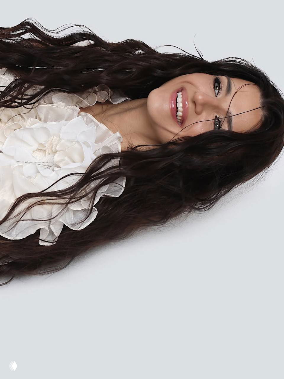 Профильный студийный портрет женщины в белом, длинные тёмные волосы развеваются, мягкий свет и спокойный фон для фэшн-съёмки