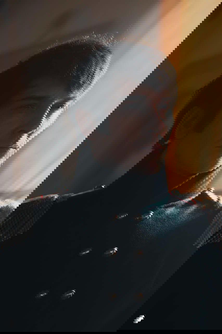 Светлый портрет Станислава Бондаренко в мундире с красным воротником и золотыми деталями — кадр с акцентом на лице актёра.