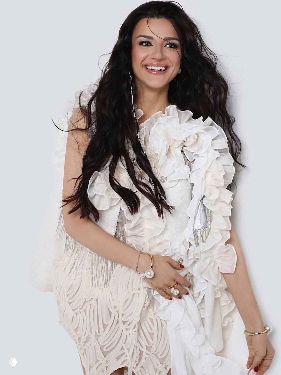 Портретная съёмка: улыбка женщины в белом наряде с объёмными рюшами, аккуратный макияж, студийный свет подчёркивает черты лица