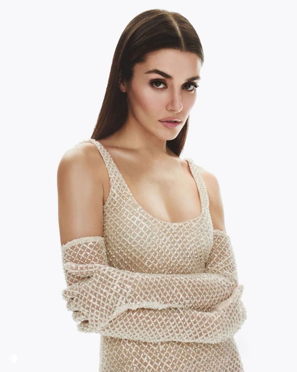 Портретная съёмка женщины в светлом платье с двойными прозрачными рукавами на нейтральном фоне, строгий взгляд в кадр.