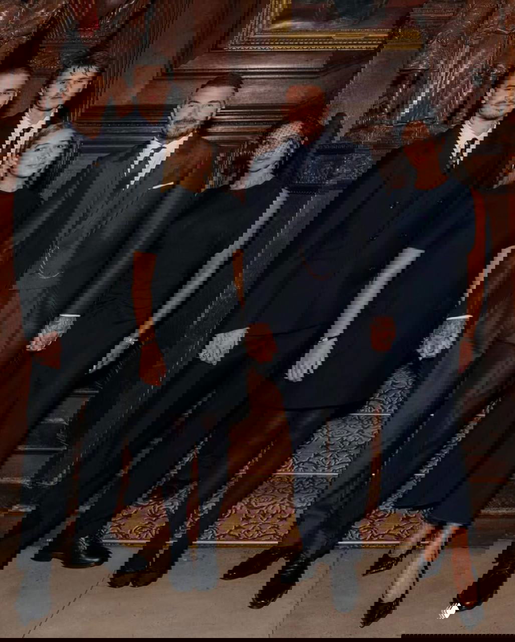 Семейный портрет Бекхэмов в официальных тёмных нарядах внутри торжественного интерьера: родители и дети стоят вместе после церемонии.