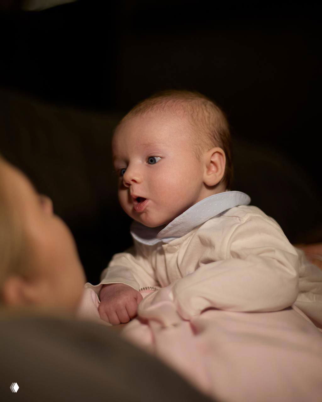 Крупный портрет малыша Миши, лежащего на пелёнке, внимание на выражении лица и широко открытых глазах новорождённого.