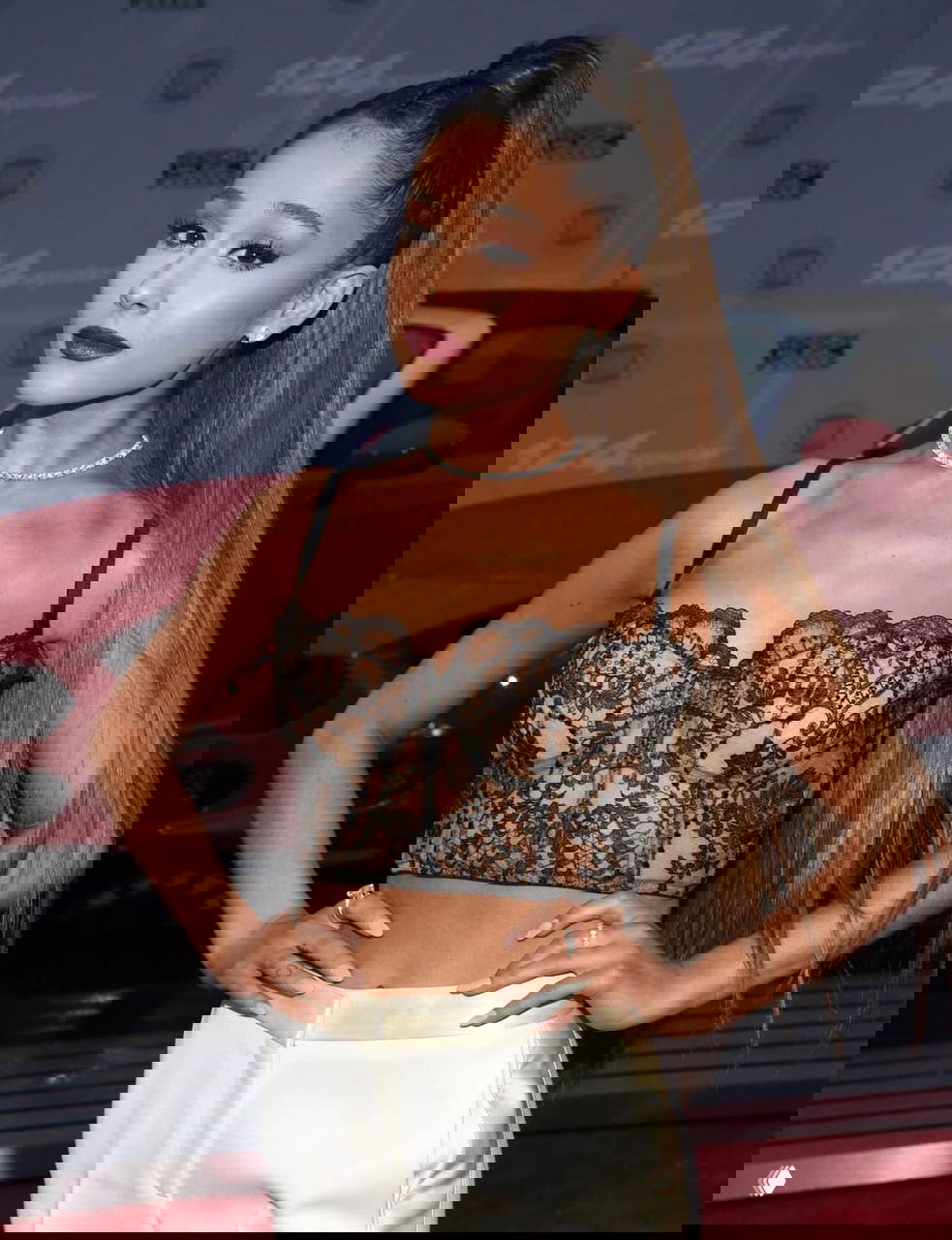 Женщина в чёрном кружевном топе на красной дорожке: портрет для модного мероприятия с акцентом на макияж и прическу в модном образе.