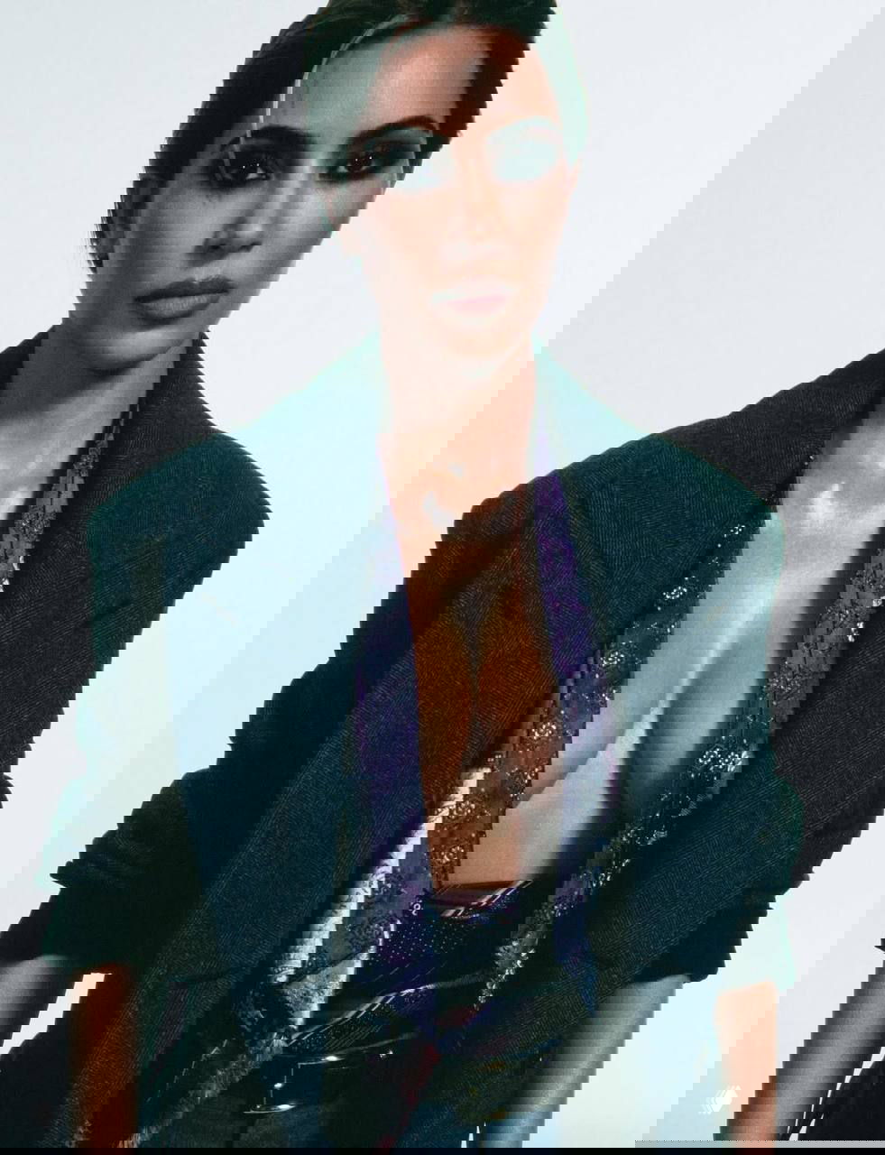 Портрет женщины в жакете с открытым декольте, студийный свет подчёркивает текстуру кожи и макияж — кадр для модной кавер‑стори.