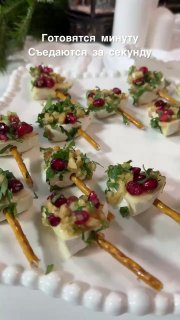 Видео с сервировкой: маленькие закуски на шпажках, украшенные зернами граната и зеленью, подпись о быстрой готовке на экране.
