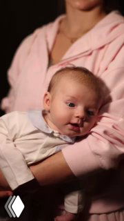 Вертикальный кадр с мамой Сашей Трусовой и ребёнком Мишей — тёплое домашнее видео с близким планом, смягчённое освещение.