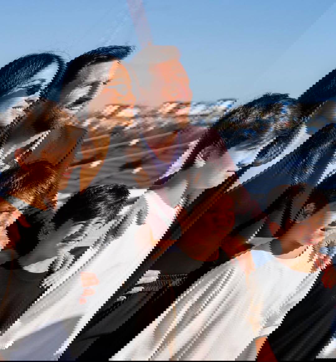 Антонелла и Лионель Месси улыбаются рядом с тремя сыновьями на солнечном фоне нового стадиона — семейная сцена во время торжества.