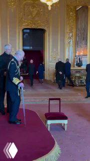 Интерьер одного из залов Виндзорского замка во время торжественной церемонии посвящения: ковровое покрытие, позолоченные панели и служащие на заднем плане.