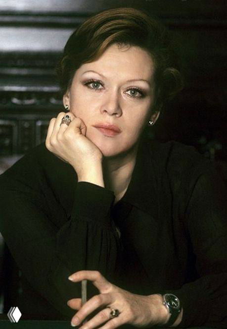 Портрет Алисы Фрейндлих в зрелом возрасте, крупный план лица в задумчивой позе, классический образ актрисы на нейтральном фоне, кинематографический свет.