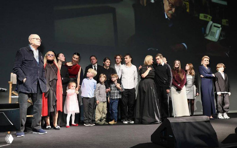 Гости и родственники в зале на праздничном вечере: официальная атмосфера, вечерние наряды и групповые портреты семьи режиссёра.