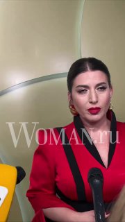 Певица в красном пиджаке у микрофона на светлом фоне с водяным знаком Woman.ru — портретный кадр с церемонии.