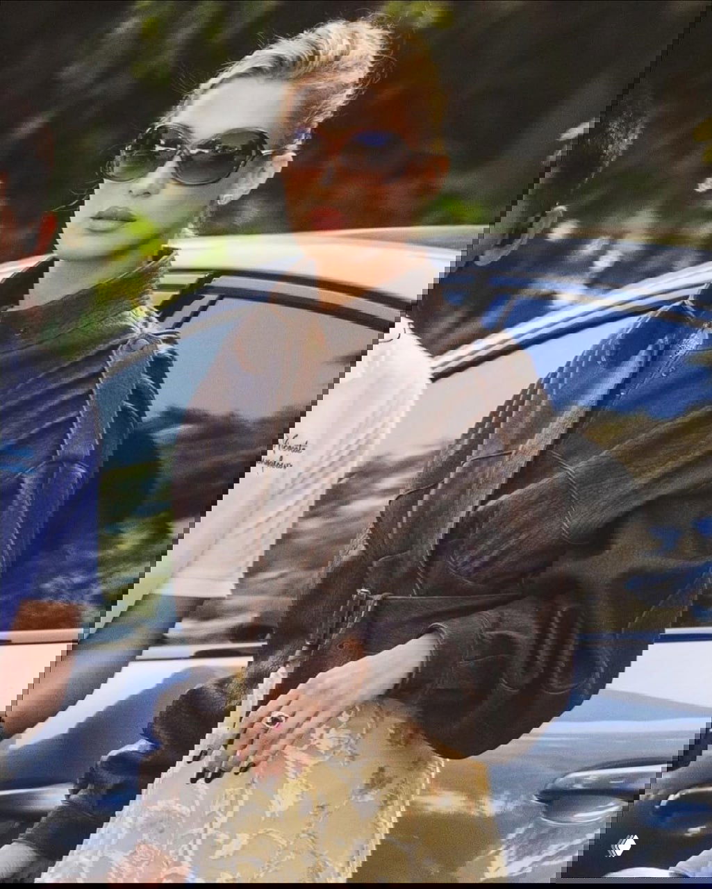 Белла Хадид в коричневом кожаном бомбере Chloé и солнцезащитных очках на фоне автомобиля: уличный стритстайл-снимок из Лос‑Анджелеса, подчеркнут винтажный образ.