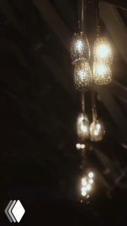 Крупный план подвесных декоративных светильников в тёплом свете на тёмном фоне — атмосферная интерьерная фотография вечернего пространства.