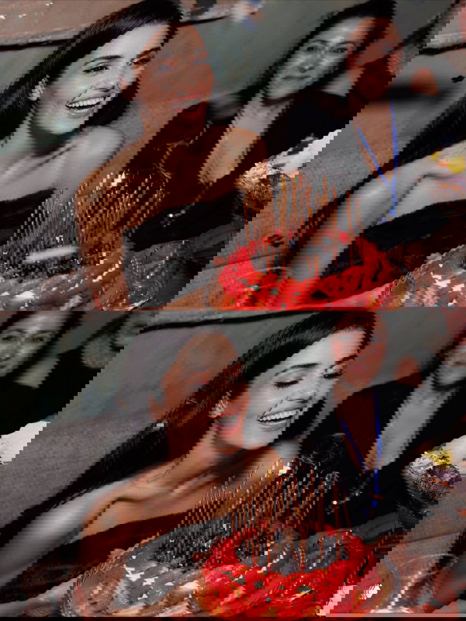 Ханде Эрчел смеётся за праздничным столом рядом с клубничным тортом и множеством тонких свечей на вечеринке в Москве.