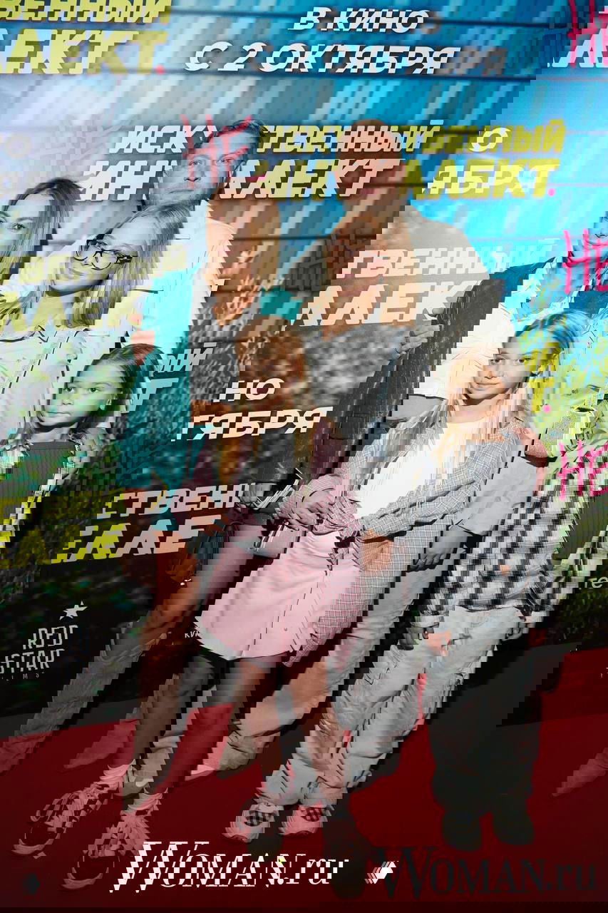 Дарья Сагалова с семьёй на красной дорожке премьерного показа: актриса с супругом и тремя детьми позируют перед фотофоной на мероприятии.