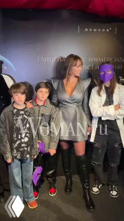 Полина Диброва в серебристом платье, Дмитрий Дибров и дети на красной дорожке премьеры «Щелкунчик» на фоне баннера иммерсивного театра.