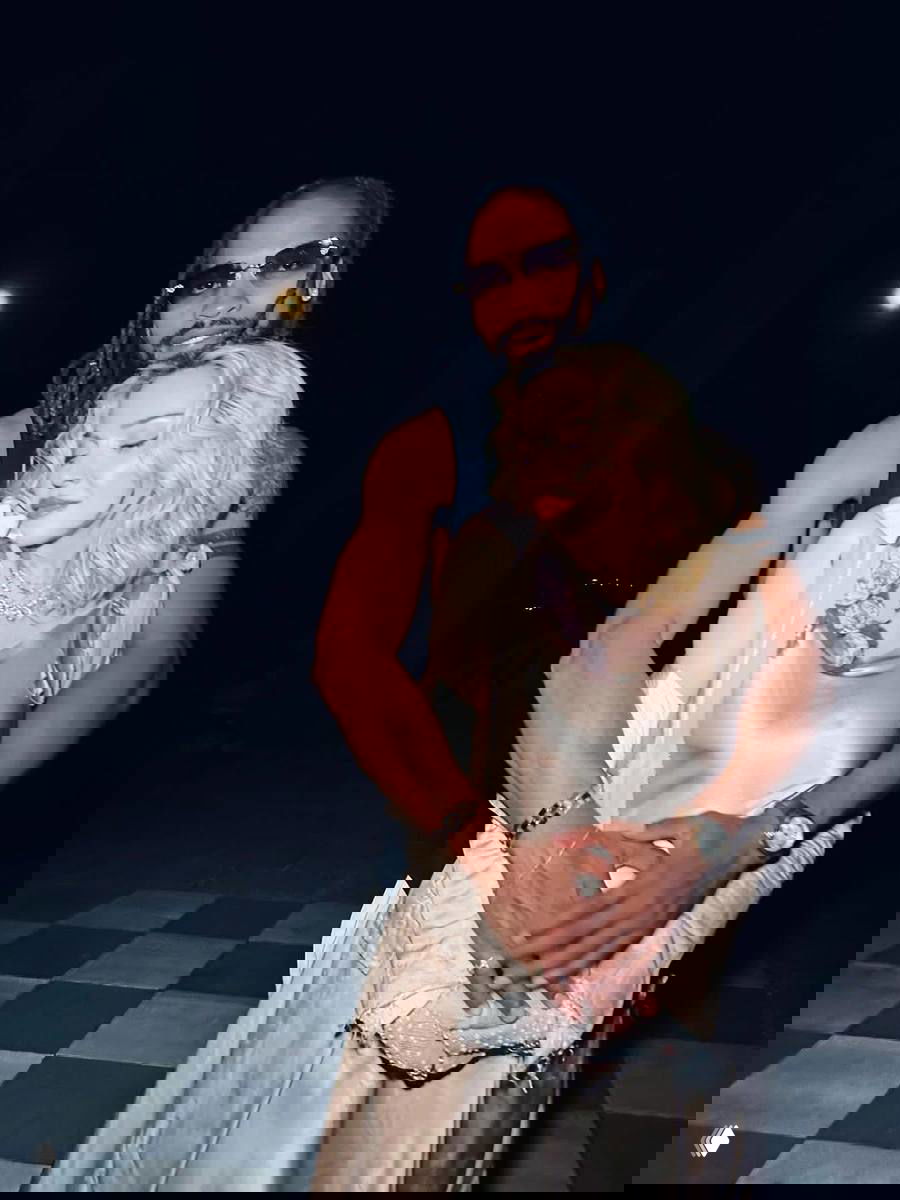 Ночное портретное фото: Мадонна в светлом шелковистом платье обнимает своего бойфренда Акима Морриса на улице.