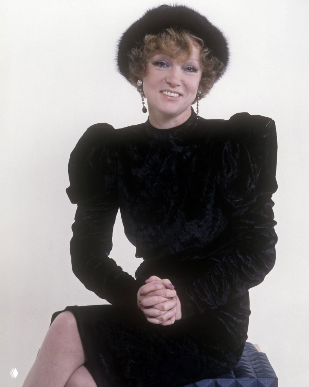 Студийный портрет в тёмном платье с крупными украшениями и выразительным макияжем; спокойная поза, архивная фотография актрисы.