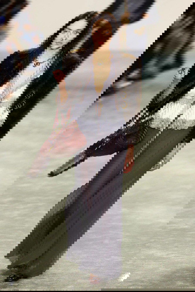 Модель на подиуме в бохо-образе несёт тёмно-коричневую сумку Chloé Paddington, видна золотая фурнитура и подвеска