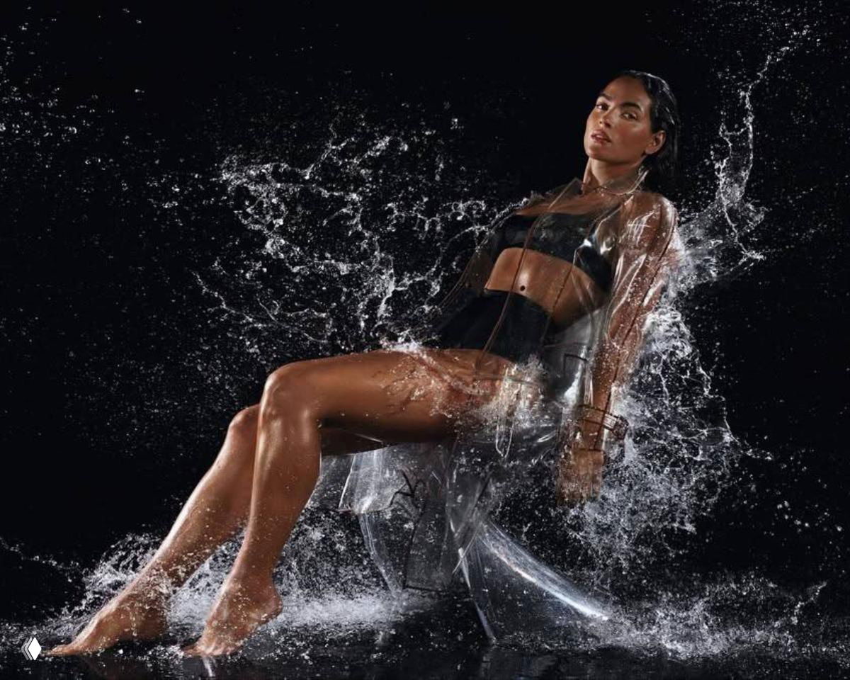 Динамичный портрет в чёрном фоне, брызги воды и прозрачные элементы вокруг тела модели создают эффект взаимодействия со стихией воды.