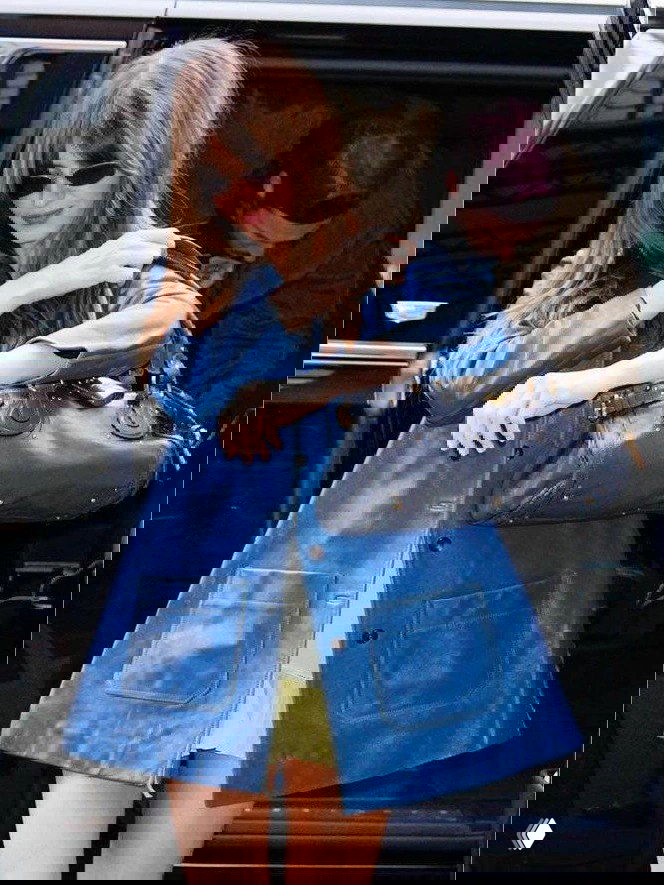 Уличный кадр: женщина в синем плаще выходит из машины с тёмно-синей сумкой Chloé Paddington в повседневном стиле