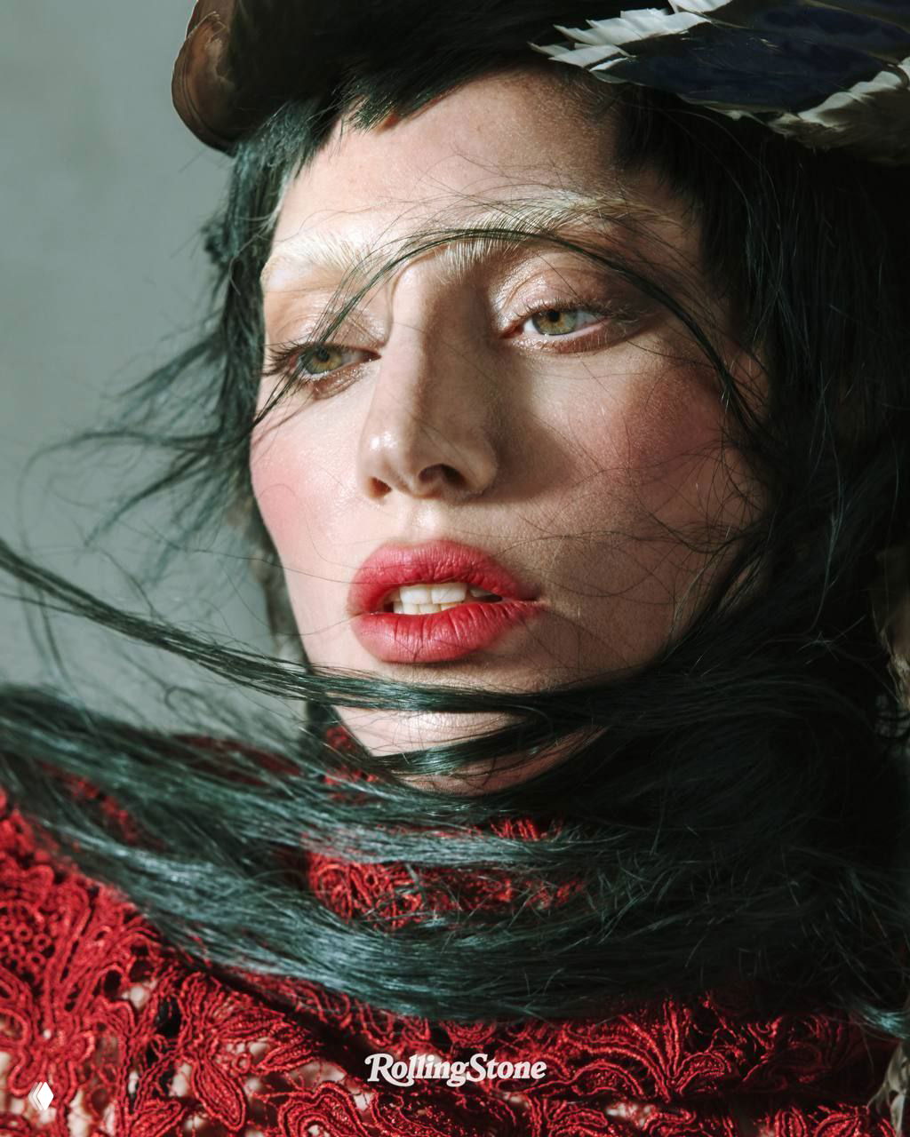 Полный рост на постаменте с перьями и тенями, женщина в коротком чёрном костюме и высоких чулках в стиле fashion-editorial.