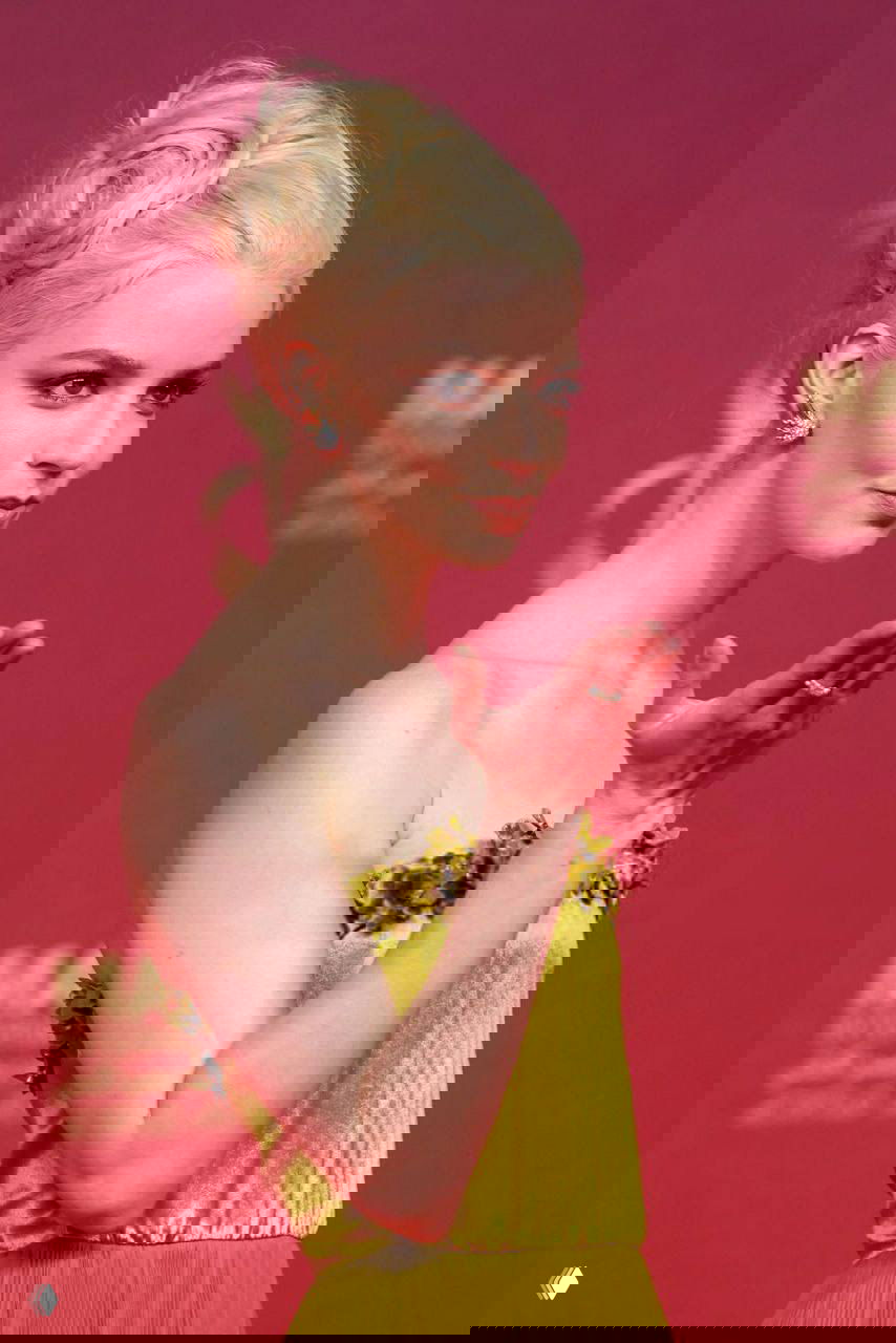 Аня Тейлор‑Джой в собранной причёске с узорами, похожими на розы, в жёлтом платье на красной дорожке кинофестиваля Маракеш.