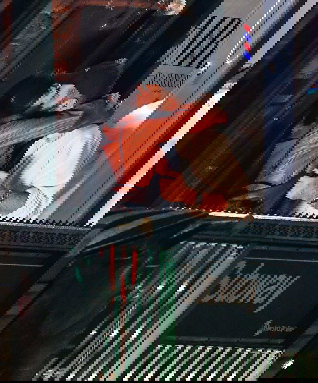 Ночное папарацци-снимок: Эмили Ратаковски в коричневом кожаном плаще обнимает мужчину у входа в метро, городская улица, уличные огни