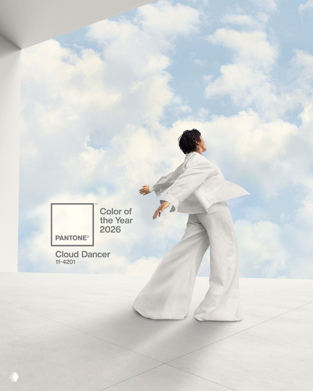 Модель в белом костюме позирует в минималистичном пространстве на фоне голубого неба с облаками и логотипа Pantone, иллюстрируя цвет года 2026 Cloud Dancer.