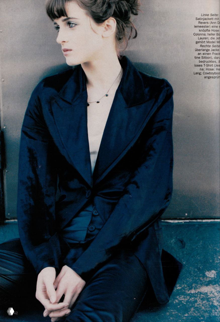 Крупный профильный портрет: модель в сатиновом пиджаке смотрит в сторону, минималистичный макияж и аккуратная причёска в спокойной цветовой гамме, кадр из модного архива.