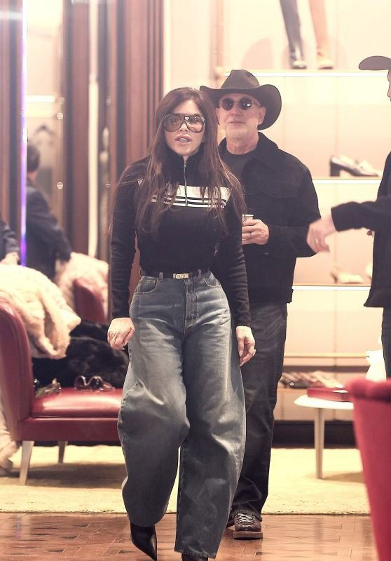 Крупный план женщины в повседневном образе: джинсы свободного кроя и тёмный верх, кадр из интерьера бутика или улицы.