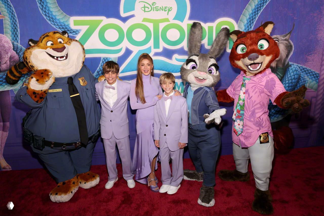 Семья Шакиры позирует рядом с ростовыми фигурами персонажей «Зверополиса», все в лавандовом: костюмы детей и платье певицы на фоне баннера премьеры.