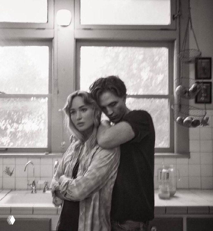 Дженнифер Лоуренс и Роберт Паттинсон в чёрно‑белом кадре на кухне, актёры позируют близко друг к другу в интимной и атмосферной фотосессии.