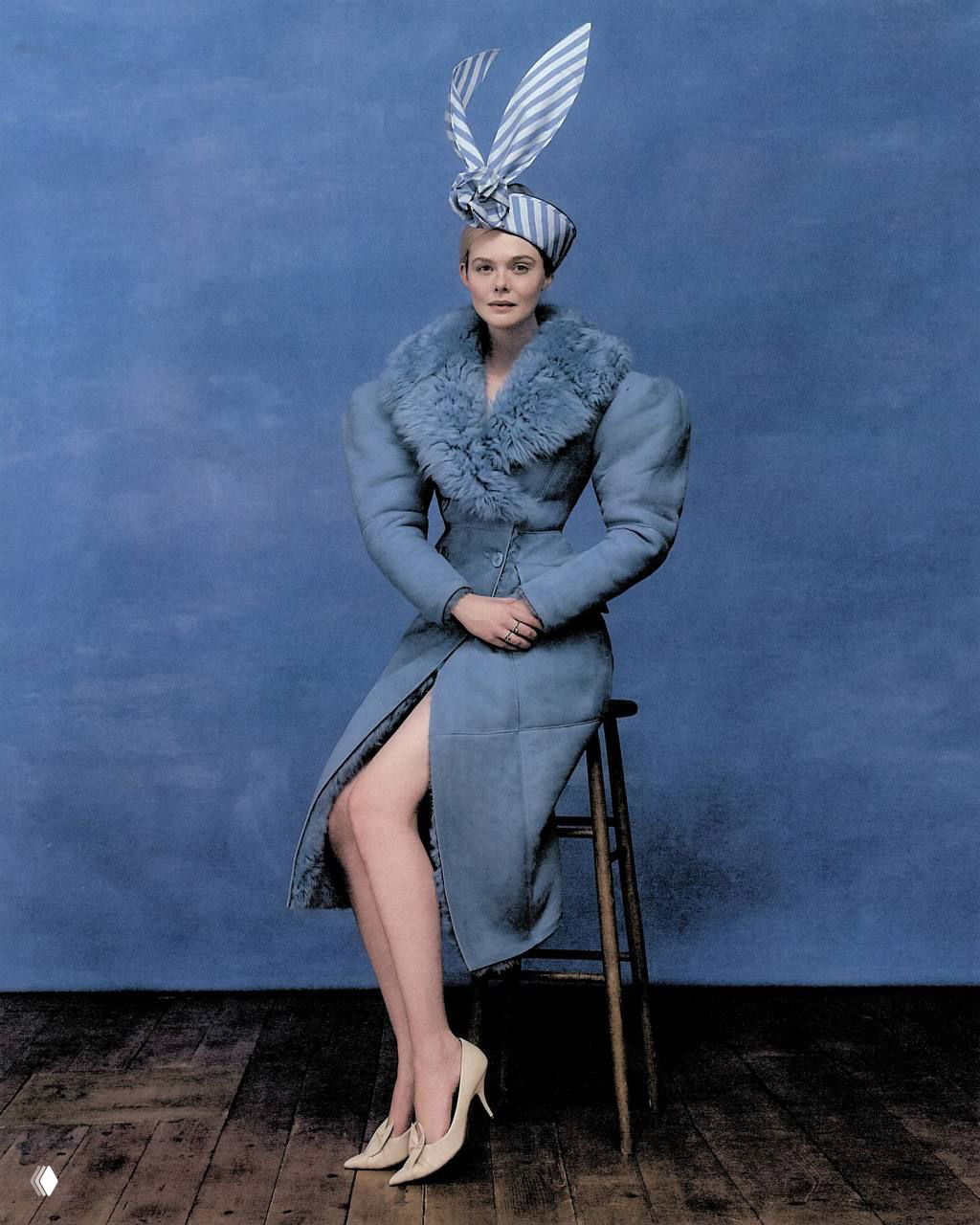 Портрет Эль Фаннинг в голубой шубе и тюрбане на синем фоне — ретро-гламурный кадр из журнальной съёмки.