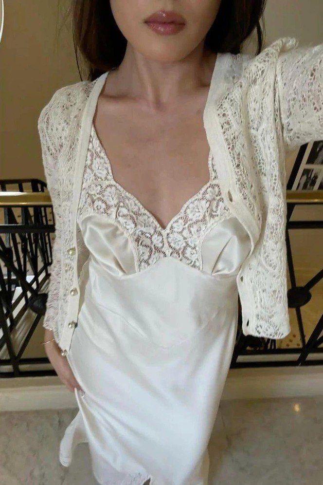 Крупный план верхней части белого платья с кружевной вставкой и лёгким кардиганом поверх — деликатный повседневный вариант с ретро‑нотами.