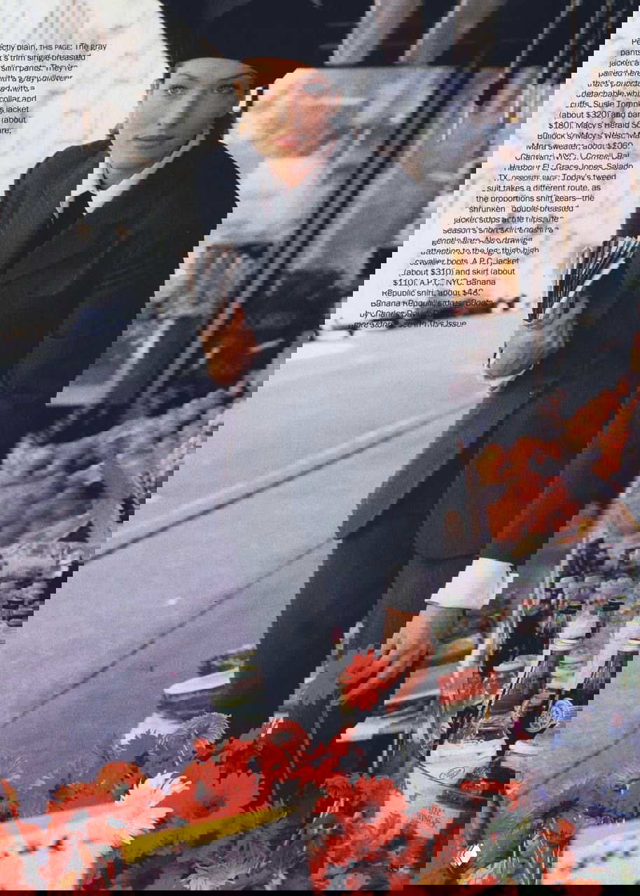 Модель в классическом костюме с беретом у цветочного прилавка, сочетание строгого офисного и уличного стиля 90-х.